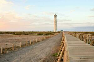 uma farol carrinhos dentro a meio do uma seco campo foto