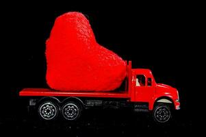 uma vermelho caminhão com uma coração em forma Rocha em a costas foto