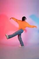 imagem do uma jovem ásia pessoa dançando em uma néon colori fundo foto