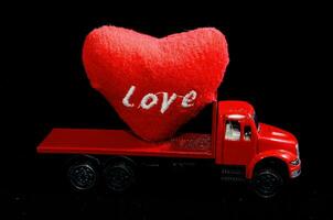 uma vermelho caminhão com uma coração em a costas foto