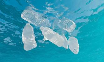 garrafas plásticas flutuando sob a água do mar foto