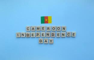 janeiro 1, independência dia dentro Camarões, bandeira do Camarões, minimalista bandeira com de madeira cartas em uma azul fundo foto