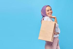 retrato de uma mulher feliz e pensativa segurando sacolas de compras foto