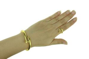 mão de mulher com pulseira de ouro e joias de anel