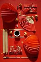 postura plana de leques japoneses e objetos chineses decorativos em fundo vermelho foto