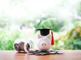 porquinho banco com graduação chapéu em pilha do moedas. a conceito do salvando dinheiro para Educação, aluna empréstimo, bolsa de estudos, taxa escolar honorários dentro futuro foto