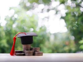 graduação chapéu em pilha do moedas. a conceito do salvando dinheiro para Educação, aluna empréstimo, bolsa de estudos, taxa escolar honorários dentro futuro foto