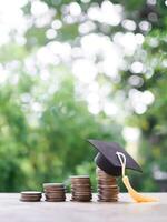 graduação chapéu em pilha do moedas. a conceito do salvando dinheiro para Educação, aluna empréstimo, bolsa de estudos, taxa escolar honorários dentro futuro foto