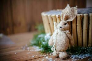 tricotado Coelho às Natal de madeira cesta dentro neve foto