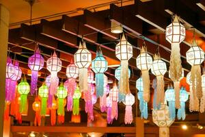 fechar-se colorida perspectiva Visão do tailandês lanna estilo lanternas para suspensão em a teto e virar em luz às noite. foto