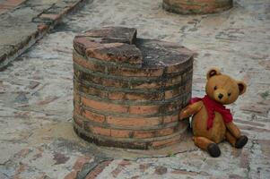 Urso de pelúcia Urso sentado em a parede foto