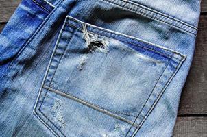 falta de jeans azul e textura de jeans no chão de madeira foto