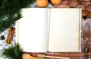 Natal cozimento conceito. vintage receita livro, Natal árvore e e especiarias em a de madeira mesa. topo visualizar. fechar-se. cópia de espaço. foto