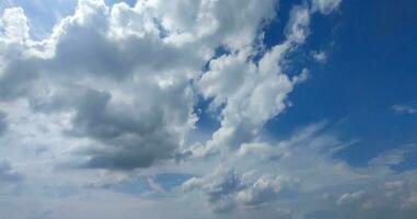 uma azul céu com nuvens e uma poucos nuvens, azul céu, branco nuvem Tempo lapso do nuvens dentro a céu, a Sol brilha através a nuvens dentro isto foto, dramático céu nuvens foto