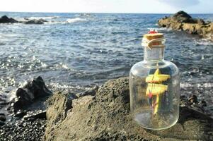 uma navio dentro uma garrafa em a de praia foto