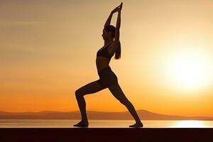 silhueta do jovem mulher praticando ioga em a de praia às pôr do sol, jovem mulher praticando ioga dentro a natarajasana posição, traseiro lado visualizar, não face revelado, não deformação, ai gerado foto