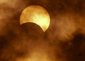 a Sol é visto através a nuvens durante uma solar eclipse foto