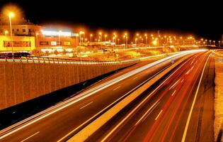 uma rodovia às noite com carros dirigindo em isto foto