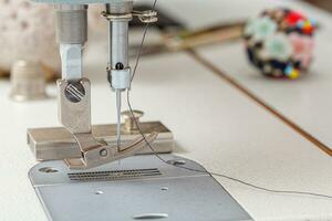 de costura máquina agulha com fio e tecido foto