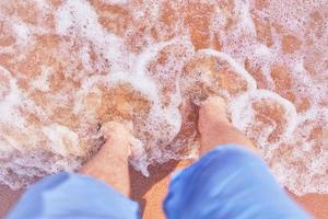 pés masculinos na praia foto