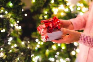 mãos segurando uma caixa de presente. conceito de felicidade, natal ou ano novo.