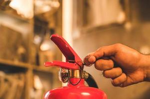 Feche o bombeiro de mão usando extintor de incêndio. foto