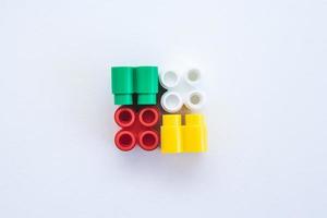 tijolos de plástico coloridos e detalhes de brinquedos em um fundo branco foto