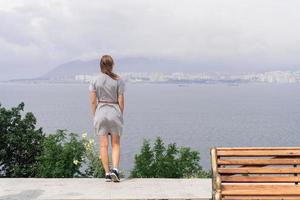 vista traseira de uma jovem olhando a paisagem urbana
