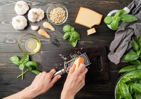 passo a passo preparando o molho pesto italiano. passo 3 - ralar queijo foto