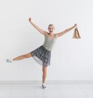 mulher sorridente dançando com sacolas de compras ecológicas e cartão de crédito