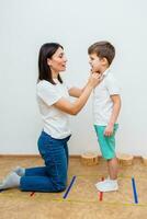 atraente mulher discurso terapeuta ensina criança para pronunciar sons e palavras corretamente dentro escritório foto