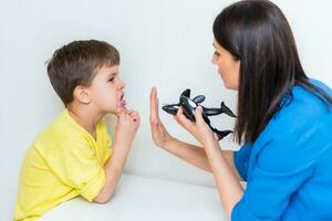fofa mulher discurso terapeuta ensina criança para pronunciar palavras sons e cartas corretamente dentro escritório foto