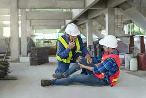 uma trabalhador pernas estava ferido às site, uma colega resgatado ele a partir de acidente e usando walkie-talkie para ligar primeiro ajuda equipe.conceito risco gerenciamento, segurança às acidente de trabalho dentro local trabalhos foto