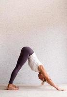 jovem atraente praticando ioga, vestindo roupas esportivas foto