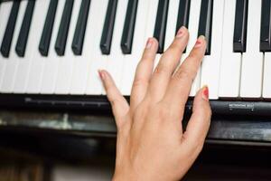 ásia Garoto jogando a sintetizador ou piano. fofa pequeno criança Aprendendo quão para jogar piano. criança mãos em a teclado interior. foto