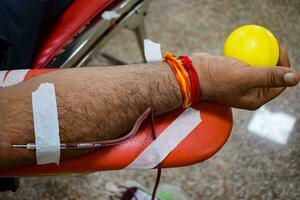 doador de sangue no campo de doação de sangue realizado com uma bola saltitante segurando na mão no templo balaji, vivek vihar, delhi, índia, imagem para o dia mundial do doador de sangue em 14 de junho de cada ano, campo de doação de sangue foto