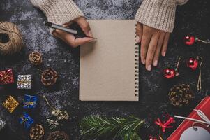 uma mão segurando uma caneta para escrever em um caderno com óculos foto