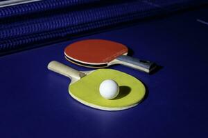 mesa tênis raquete em a azul ping pong mesa foto