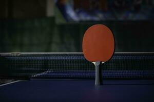 mesa tênis raquete em a azul ping pong mesa foto