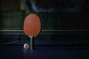 mesa tênis raquete em a azul ping pong mesa foto