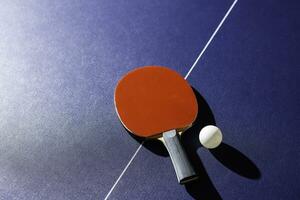 mesa tênis raquete em a azul ping pong mesa foto