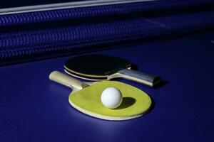 mesa tênis raquete em a azul ping pong mesa foto