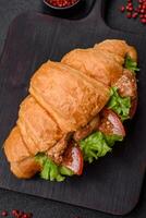 delicioso fresco crocantes croissant com frango ou carne carne, alface, tomates, especiarias e molho foto