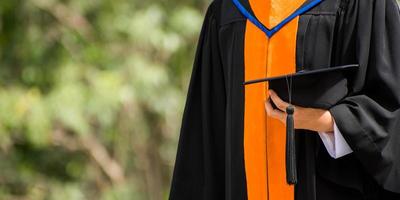 fechar pós-graduação segurando um chapéu. educação de sucesso na universidade