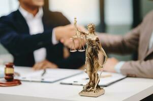 advogado masculino no escritório com escala de latão na mesa de madeira. conceito de justiça e direito foto