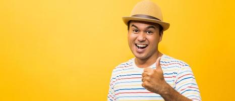 jovem asiático com chapéu feliz e surpreso ao mostrar o polegar