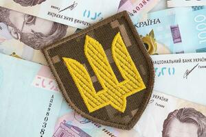 ucraniano militares símbolo e hryvnia contas. pagamentos para soldados do a ucraniano exército, salários para a militares foto