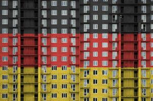 Alemanha bandeira retratado dentro pintura cores em de vários andares residente construção debaixo construção. texturizado bandeira em tijolo parede fundo foto