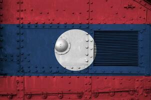 Laos bandeira retratado em lado parte do militares blindado tanque fechar-se. exército forças conceptual fundo foto