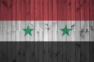 Síria bandeira retratado dentro brilhante pintura cores em velho de madeira muro. texturizado bandeira em rude fundo foto